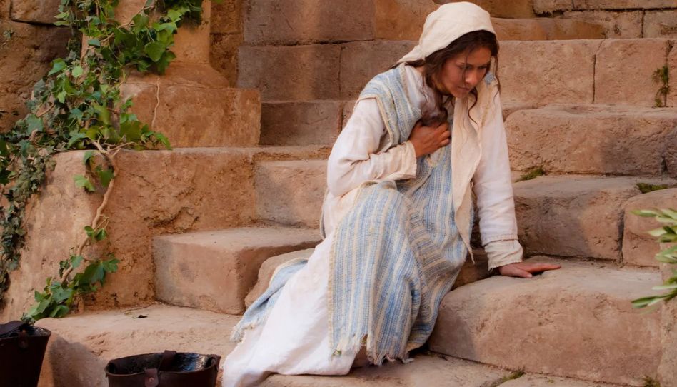 Maria mãe de Jesus sentada em uma escadaria.